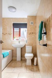 a bathroom with a toilet and a sink and a tub at Ochil View Holiday Let in Tullibody
