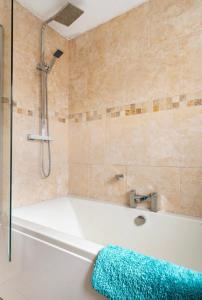 a bathroom with a bath tub with a shower at Ochil View Holiday Let in Tullibody