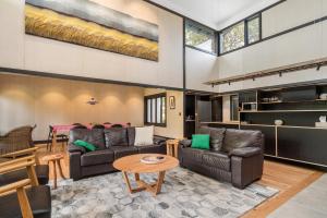 uma sala de estar com dois sofás e uma mesa em Belongil Laneway em Byron Bay