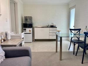 Una sala de estar con una mesa y una cocina. en Melville Views Apartment, en Albany