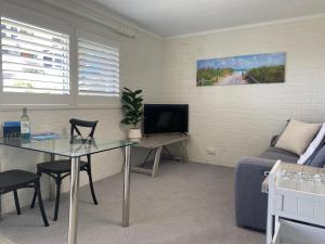 una sala de estar con una mesa y un sofá en Melville Views Apartment, en Albany