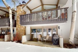 a house with a balcony and a table and chairs at Lichenhearth # 4 in Snowmass Village