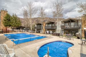 a pool at a resort with tables and chairs at Lichenhearth # 4 in Snowmass Village