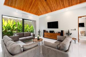 un soggiorno con 2 divani e una TV a schermo piatto di Luxury Balinese Private Pool Villa! KBR12 a Nathon Bay