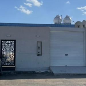 eine weiße Garage mit einer Tür und einem Fenster in der Unterkunft استراحة عمر in Ha'il