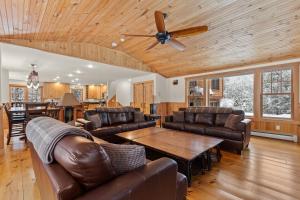 a living room with leather furniture and a ceiling fan at Woodford Lodge in North Creek