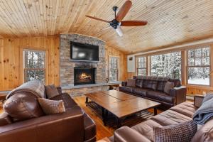a living room with leather furniture and a fireplace at Woodford Lodge in North Creek