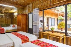 sypialnia z 2 łóżkami i oknem w obiekcie Mai Chau Moment Spa & Resort w mieście Mai Châu