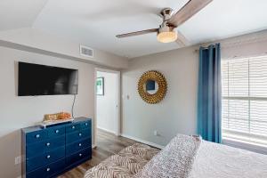 een slaapkamer met een blauwe dressoir en een flatscreen-tv bij LIV Long and Prosper in Port Isabel