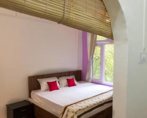 a bed in a room with a window at Mohija Homestay in Kandāghāt