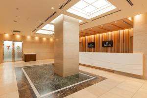 a lobby with a reception desk and a skylight at The OneFive Osaka Namba Dotonbori in Osaka