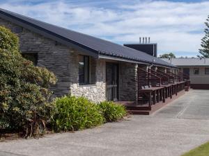 a stone building with a porch and a bench at Paroa Hotel in Greymouth