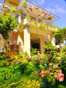 a building with a garden with flowers and plants at Homestay Sala in Ho Tram