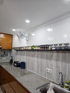eine Küchentheke mit einem Waschbecken und einem Spiegel in der Unterkunft Welcome to Serenity Villa. in Munggu