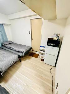 Habitación pequeña con 2 camas y armario. en Shibuya Honmachi Hana House, en Tokio