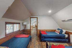 een zolderkamer met 2 bedden en een raam bij Sparrow Cabin in Shaver Lake