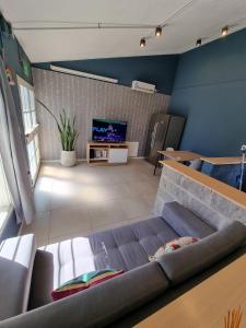 ein Wohnzimmer mit einem Sofa und einem TV in der Unterkunft SLB Apart - Studio in San Luis