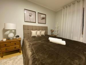 - une chambre avec un grand lit et une table de nuit dans l'établissement LUXUOSO APT ALMERIS PECCIN no Centro de GRAMADO, à Gramado