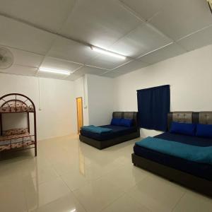 a living room with two beds and a couch at Beautiful River Homestay Kuala Pontian Rompin in Kuala Rompin