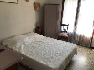 1 dormitorio con 1 cama blanca y 1 silla en Appartement Bormes-les-Mimosas, 4 pièces, 6 personnes - FR-1-251-751, en Bormes-les-Mimosas