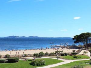 Ein Strand mit einem Haufen Leute drauf. in der Unterkunft Appartement La Londe-les-Maures, 2 pièces, 6 personnes - FR-1-251-750 in La Londe-les-Maures