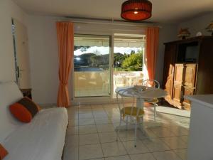 a living room with a bed and a table and a patio at Appartement Le Lavandou, 1 pièce, 4 personnes - FR-1-251-776 in Le Lavandou