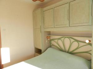 Schlafzimmer mit einem Bett und einem Holzschrank in der Unterkunft Appartement Bormes-les-Mimosas, 2 pièces, 4 personnes - FR-1-251-785 in Bormes-les-Mimosas