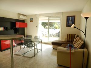 ein Wohnzimmer mit einem Tisch und einem Sofa in der Unterkunft Appartement Le Lavandou, 2 pièces, 4 personnes - FR-1-251-769 in Le Lavandou