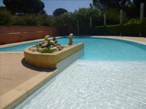 ein Schwimmbad mit einem Brunnen in der Mitte in der Unterkunft Appartement Le Lavandou, 2 pièces, 4 personnes - FR-1-251-769 in Le Lavandou