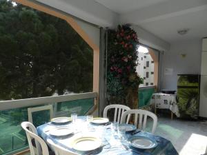 einen Tisch mit weißen Tellern und Stühlen auf dem Balkon in der Unterkunft Appartement Bormes-les-Mimosas, 3 pièces, 6 personnes - FR-1-251-771 in Bormes-les-Mimosas