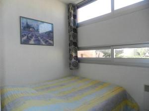 Schlafzimmer mit einem Bett und einem Fenster in der Unterkunft Appartement Bormes-les-Mimosas, 3 pièces, 6 personnes - FR-1-251-771 in Bormes-les-Mimosas
