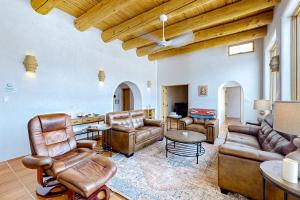 uma sala de estar com mobiliário de couro e uma mesa em Villa Grande Vista em Arroyo Seco