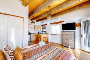 a bedroom with a large bed and a kitchen at Sunset Studio in Taos