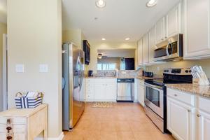 a large kitchen with white cabinets and appliances at Bethany Bay --- 30224 Driftwood Court Unit #7504 in Ocean View