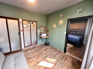 Habitación con paredes verdes, cama y suelo de madera. en Hotel Spa Casa del Sol, en Guanajuato