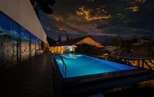 Holidays Garden by Bestinn Leisure Wayanad في كالباتّا: مسبح كبير في مبنى في الليل