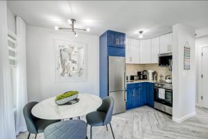 cocina con armarios azules, mesa y sillas en Sunflower Skies #1, en Fort Lauderdale