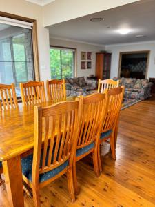 uma sala de jantar com uma mesa de madeira e cadeiras em Echo Point Village em Katoomba