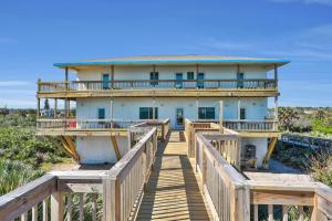 a house on a boardwalk in front of a building at Immaculate, modern stay steps to beach with amazing ocean views in Painters Hill