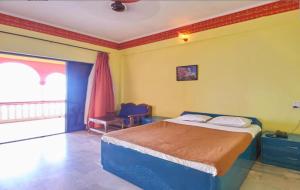 a bedroom with a large bed and a window at Shiv Sagar Palace,Ganpatipule in Ganpatipule