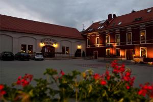 eine Gruppe von Gebäuden mit roten Blumen im Vordergrund in der Unterkunft A' PROPOS Hotel, Restauracja, Club in Wałbrzych