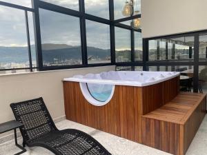 a bath tub in a room with a window at Studio Aconchegante in Poços de Caldas
