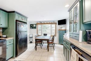 a kitchen with green cabinets and a table with chairs at Shoreline Serenade in Belmont
