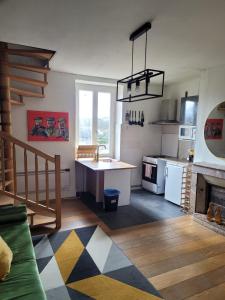 eine Küche mit einem Waschbecken und einer Theke in einem Zimmer in der Unterkunft Irie Vibes in Bourganeuf