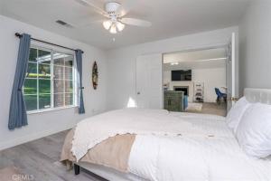 une chambre blanche avec un lit et un ventilateur de plafond dans l'établissement Mountain Retreat! 4 BDR, 2 BTH Yosemite, Bass Lake, à Oakhurst