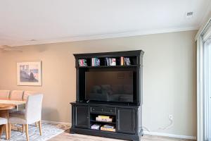 un centro de entretenimiento negro con TV en la sala de estar en Westwood --- 817 Beach Haven Unit C, en Bethany Beach