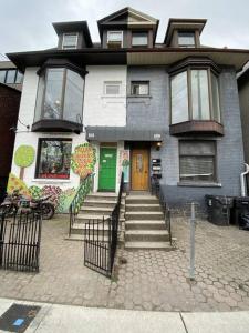 a building with a green door on a street at Cozy 2 Bedroom with Parking in Toronto
