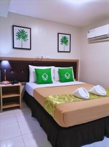 a hotel room with two beds with green pillows at Airport Poddotel Inc. in Manila +41 photos