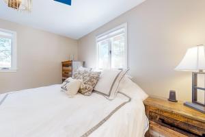 ein Schlafzimmer mit einem großen weißen Bett mit Kissen in der Unterkunft Wandering Creek Ski Chalet in Stratton Mountain