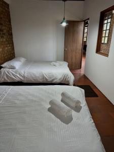 - 2 lits dans une chambre avec des serviettes à l'étage dans l'établissement Villa San Carlos, à Villa de Leyva